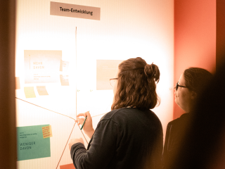 Picture of two employees in front of an illuminated wall at .diff in a working session